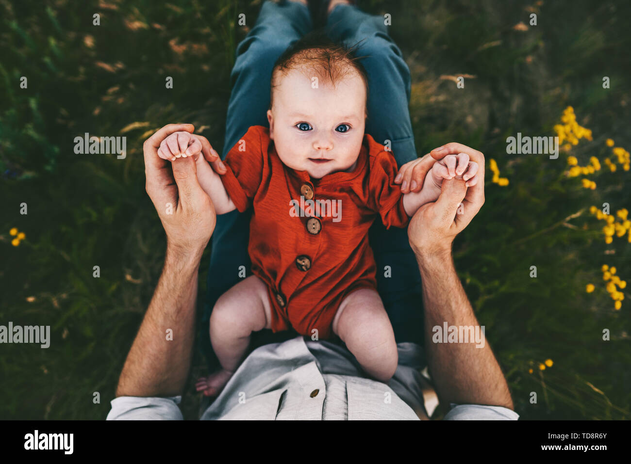 Baby infant on father knees outdoors happy family lifestyle dad and