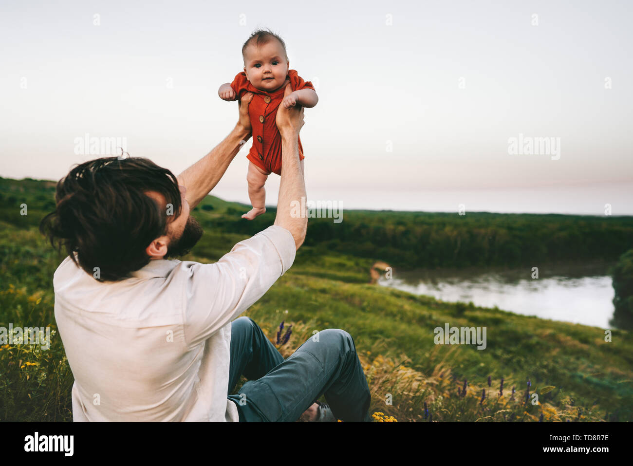 Father holding up baby outdoor happy family lifestyle Fathers day dad and infant child walking together summer vacations parenthood childhood concept Stock Photo