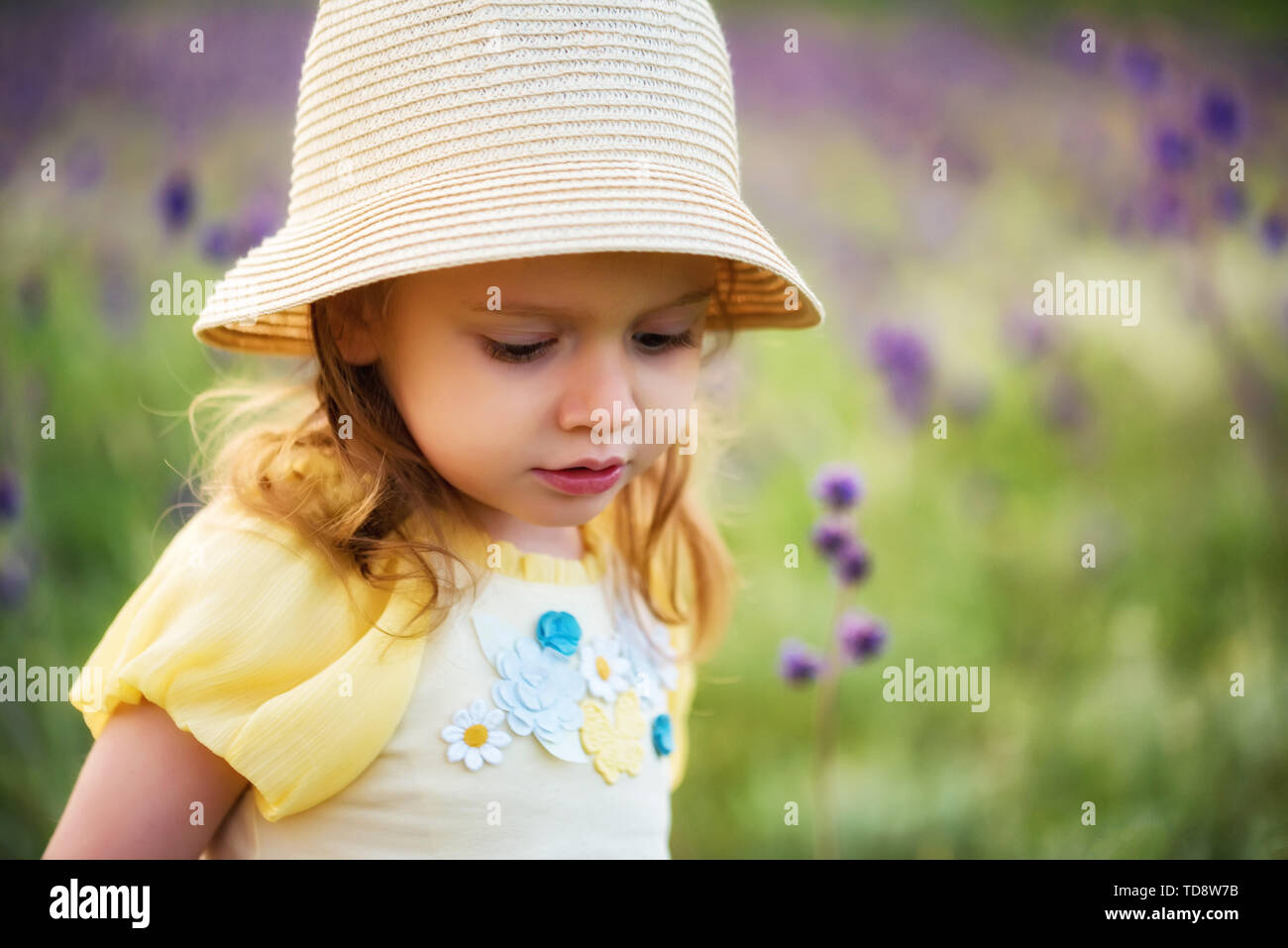 Cute serious baby girl in hat looks 