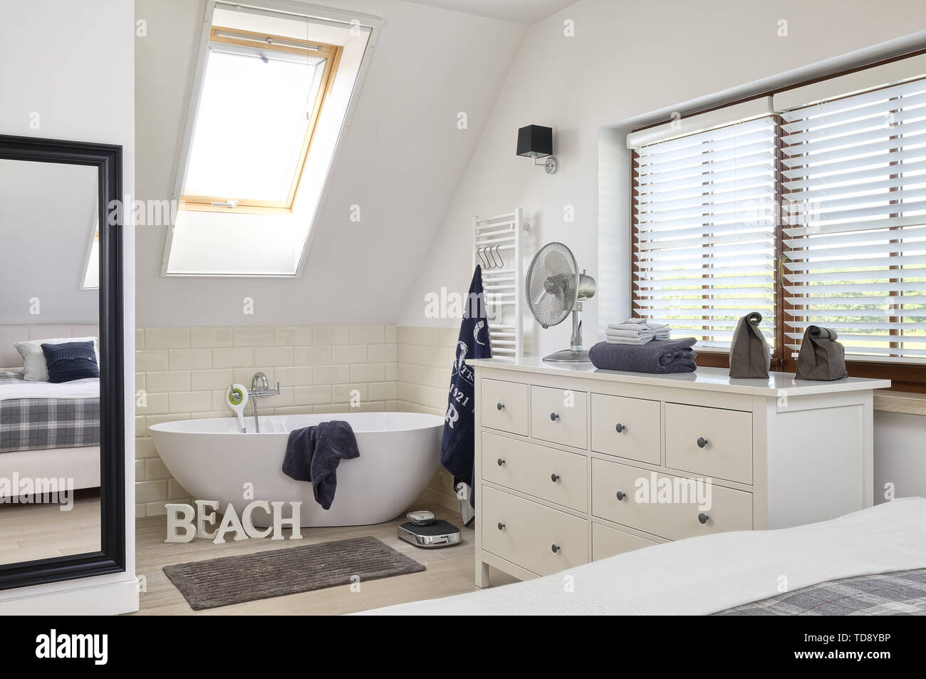 Freestanding bathtub and chest of drawers in open plan bedroom  UK & IRISH USE ONLY Stock Photo