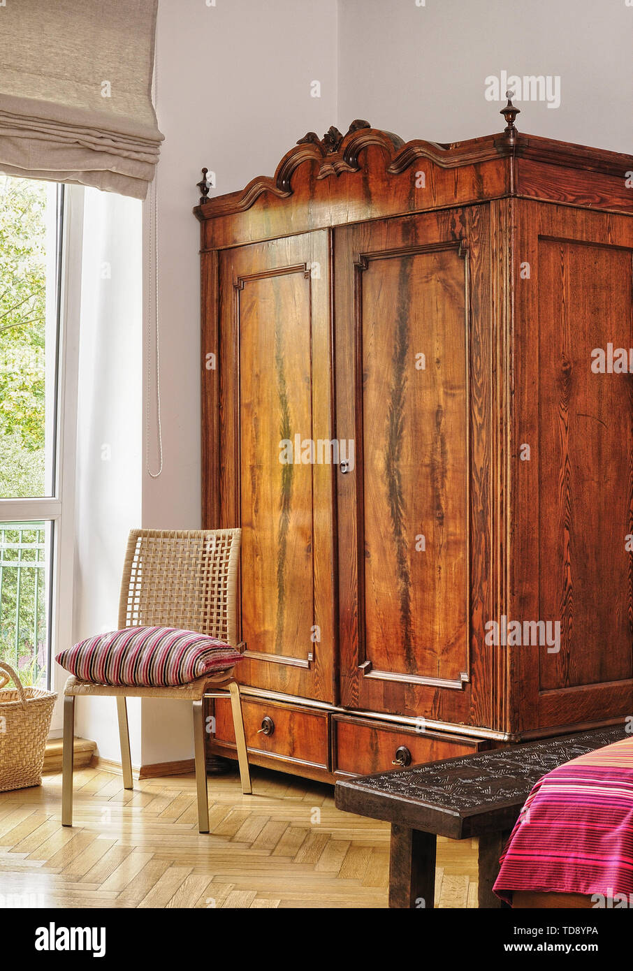 Carved Timor sitting bench next to vintage wardrobe in bedroom UK & IRISH  USE ONLY Stock Photo - Alamy
