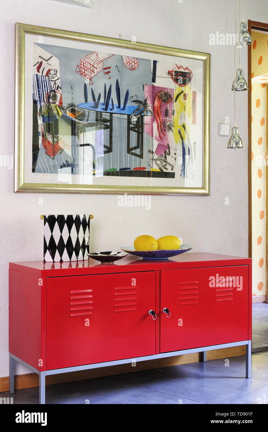 Framed modern painting above red metal cabinet next to living room entrance  UK AND IRISH RIGHTS ONLY Stock Photo - Alamy