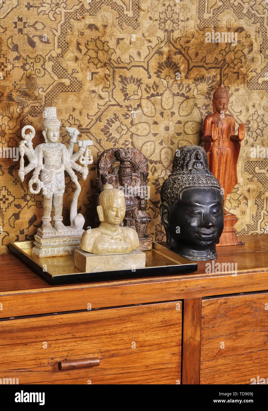 Buddha statues collection on wooden chest of drawers in living room UK