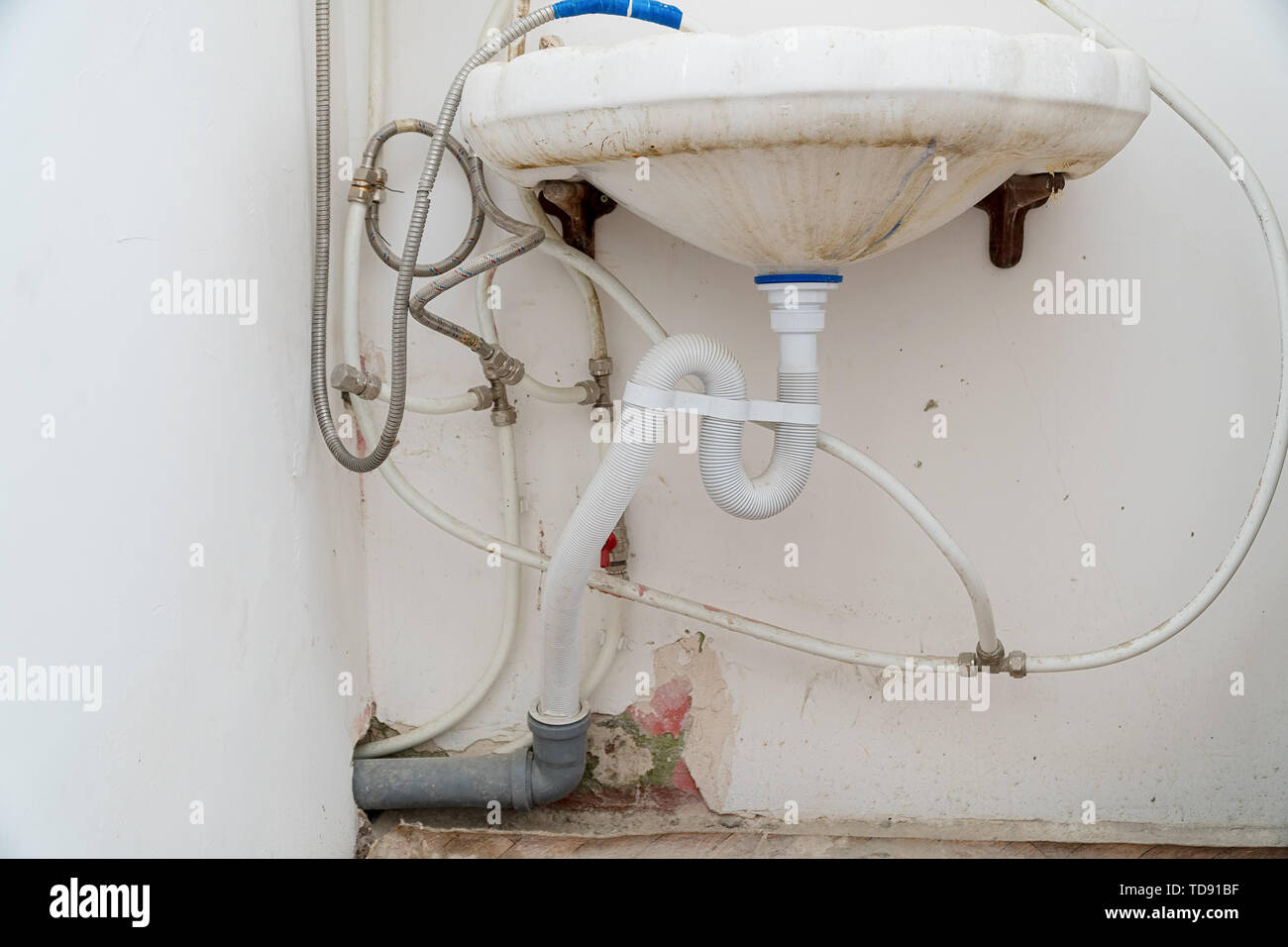Dirty sink with wrong connection of pipes and other plumbing Stock