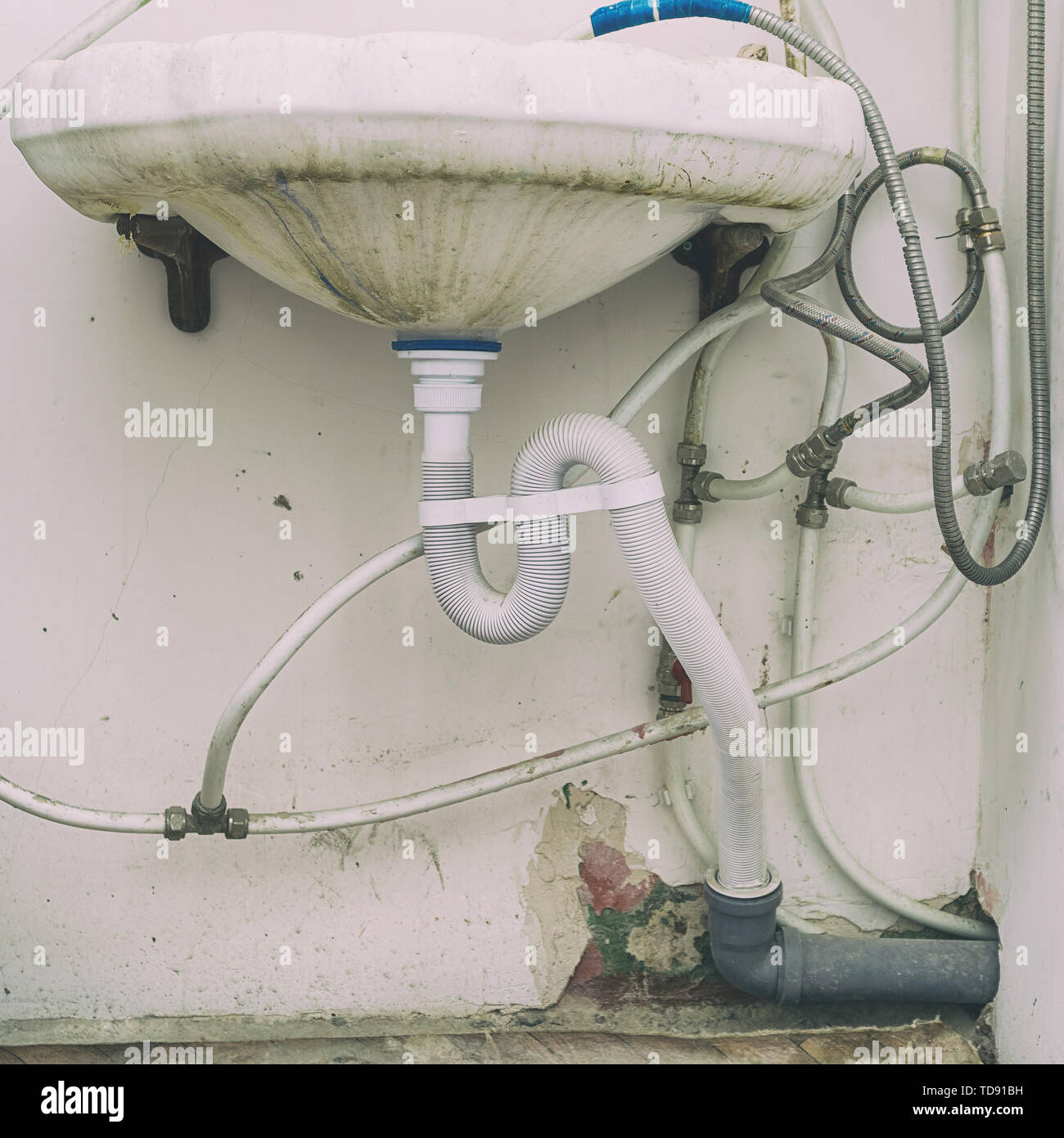 Dirty sink with wrong connection of pipes and other plumbing Stock