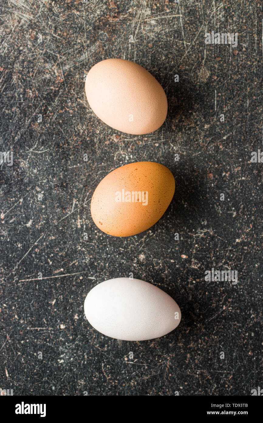 Raw chicken eggs on old kitchen table. Top view. Stock Photo