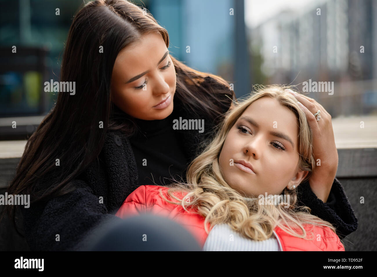 Young Woman Consoling Sad Friend In City Stock Photo
