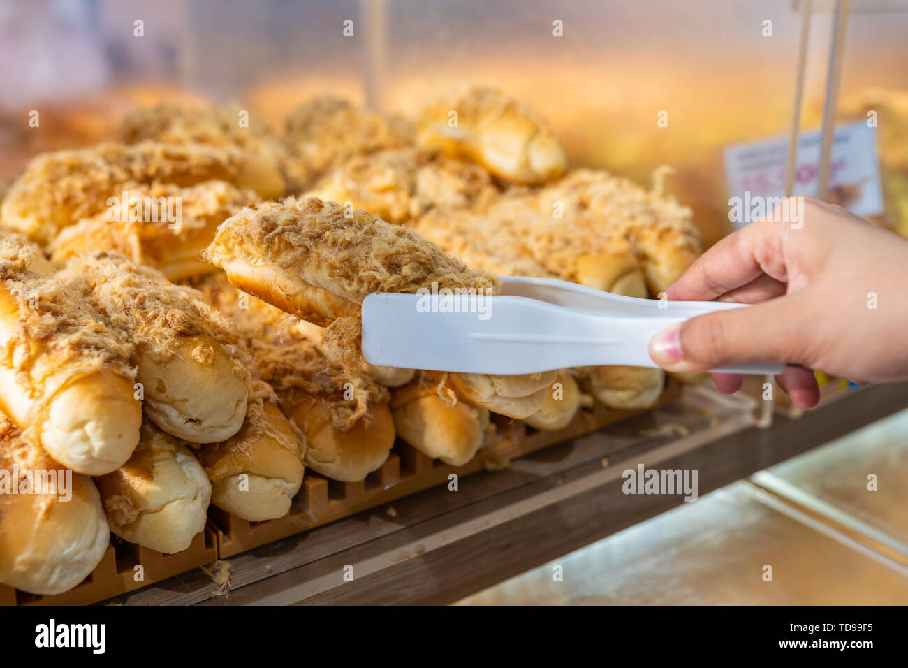 Close up of hand picking pork floss bread with clamp Stock Photo Alamy