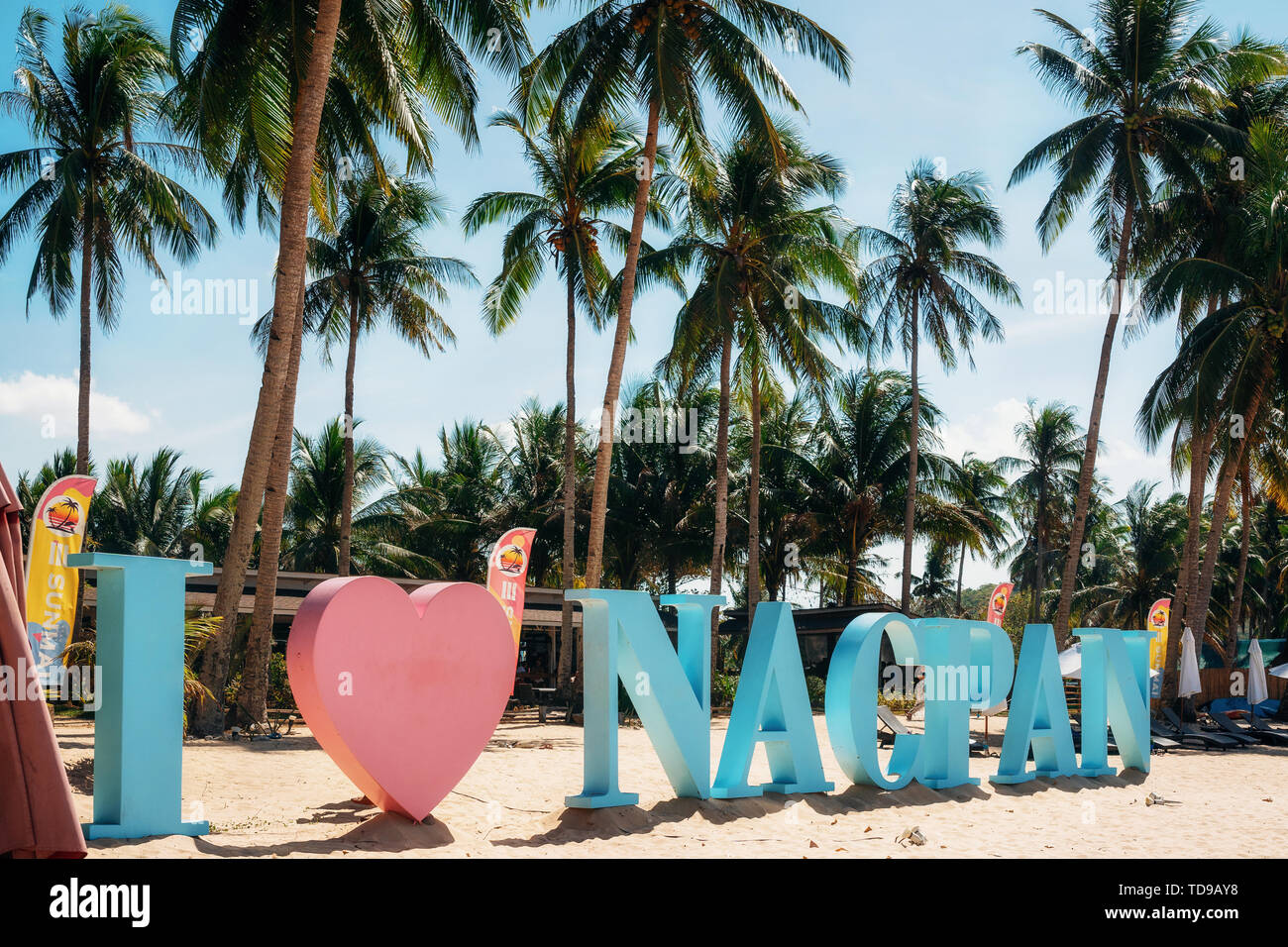 Nacpan beach, Palawan, Philippines - February 1, 2019: View of the blue and pink I love Nacpan sign on beach against palm trees, Palawan, Philippines Stock Photo