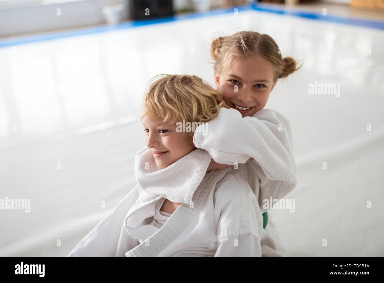 Girl happy. Beautiful positive girl feeling happy after winning aikido fight with boy Stock Photo