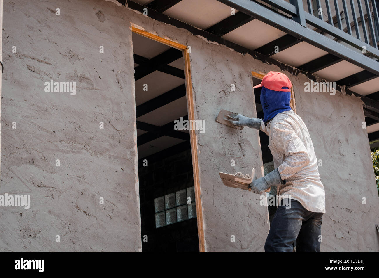 Construction Workers Plastering Building Wall Using Cement