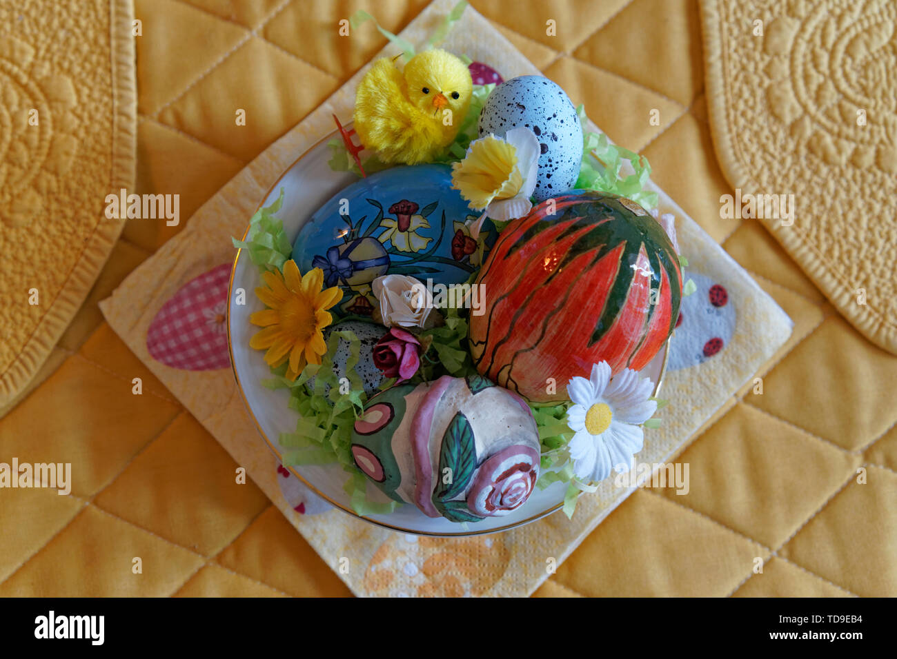 A bowl filled with colorful Easter decorations from above Stock Photo