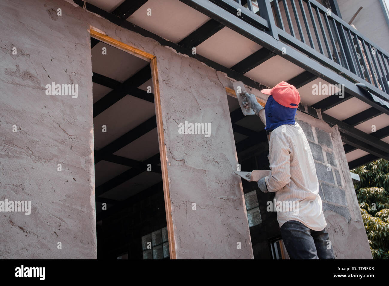 Construction Workers Plastering Building Wall Using Cement Plaster