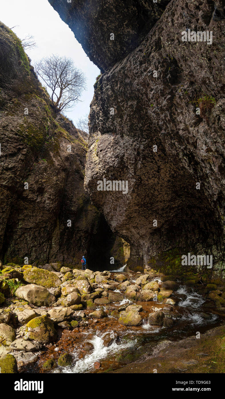 A person standing in the rocky gorge within the Alva Glen cut out by the Alva Burn, Clackmannanshire, Scotland Stock Photo