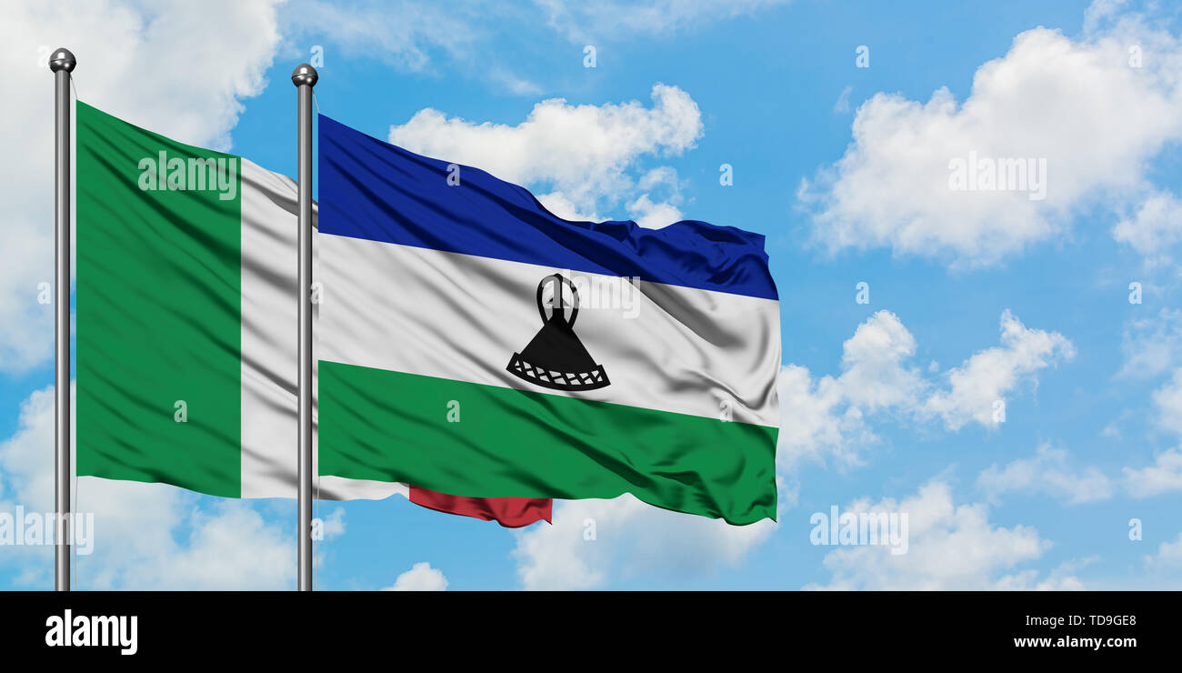 Italy and Lesotho flag waving in the wind against white cloudy blue sky ...