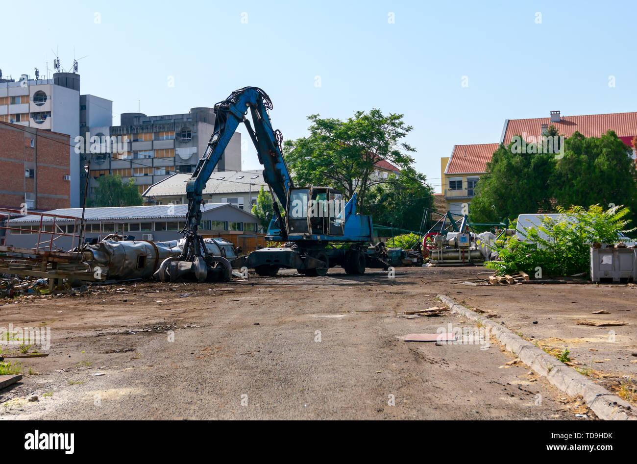 View on parked machine, loader manipulator with hydraulic Grappling claw for collecting steel scrap metal. Stock Photo
