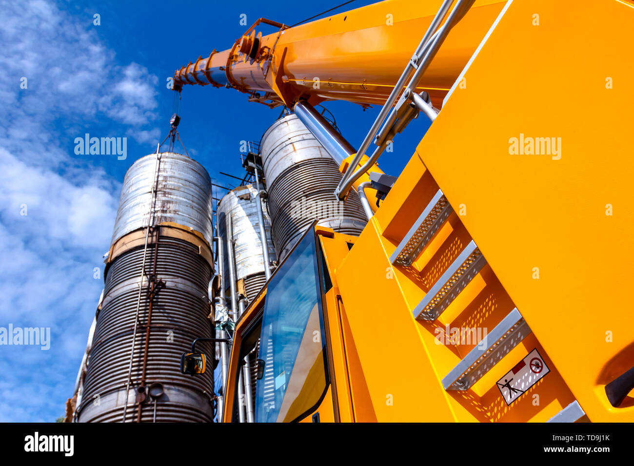 Metal ladders behind cabin on mobile crane with hook and straps is
