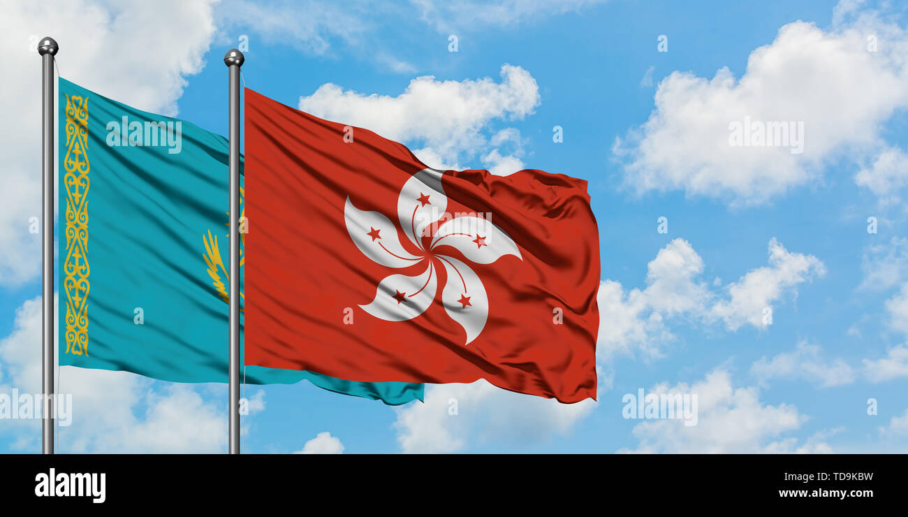 Kazakhstan and Hong Kong flag waving in the wind against white cloudy blue sky together. Diplomacy concept, international relations. Stock Photo