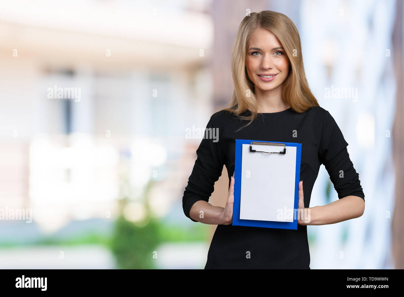 Happy smiling young beautiful business woman with clipboard Stock Photo ...