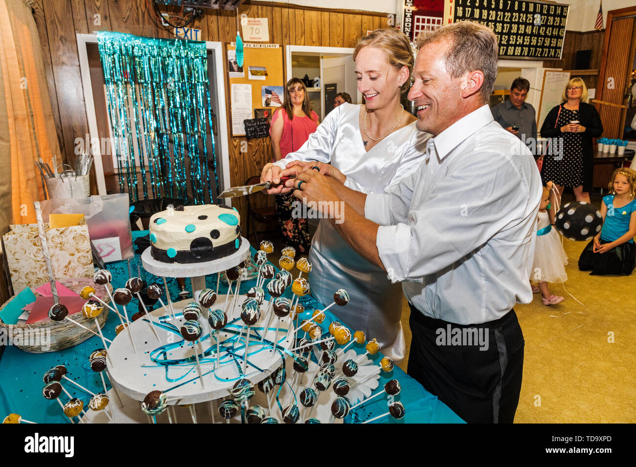 Bride & groom cut the cake at wedding reception;  Congressional Church; Buena Vista; Colorado; USA Stock Photo