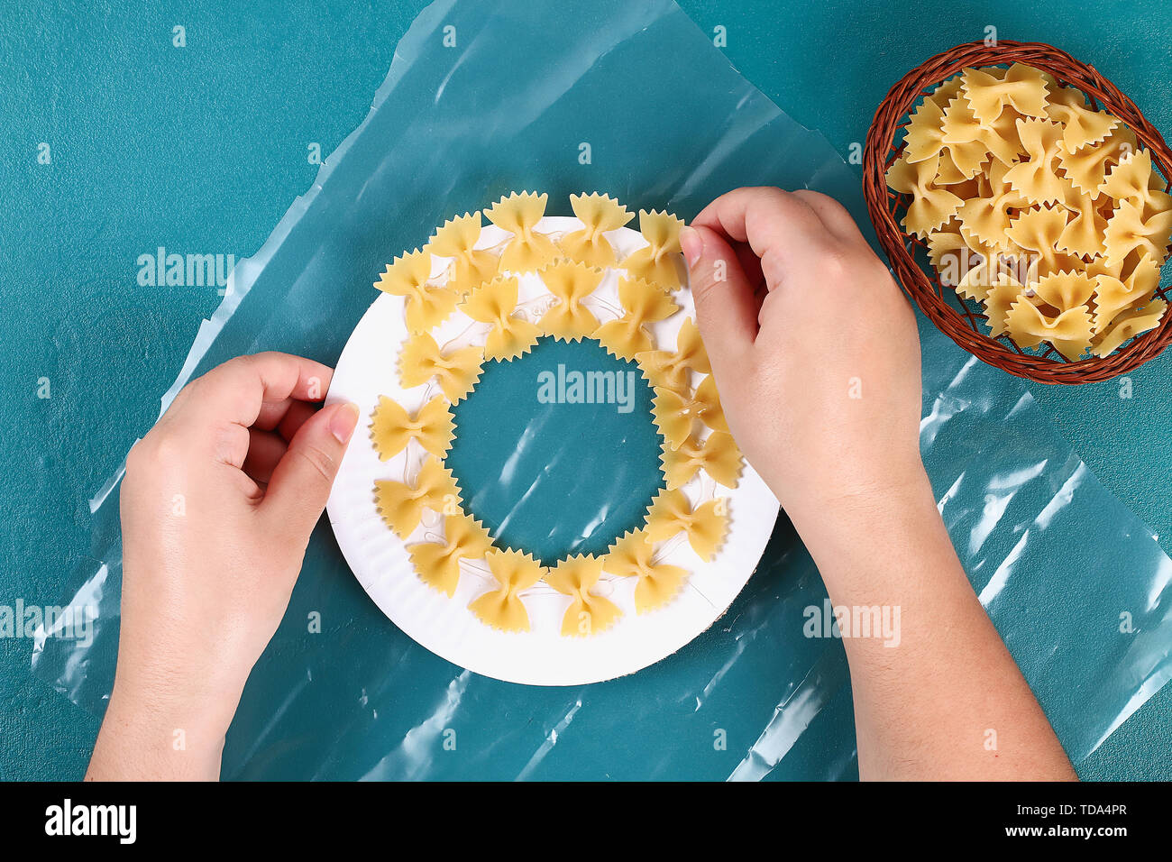 Diy Christmas pasta wreath on blue background. Gift idea, decor