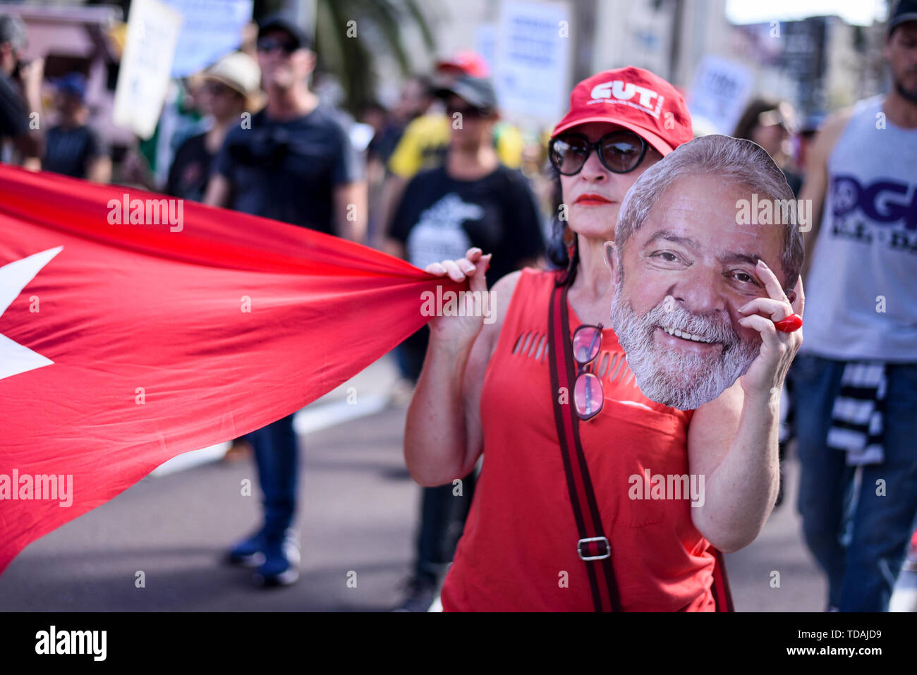 Curitiba, Brazil. 14th June, 2019. A demonstrator holds a picture of former head of state Lula da Silva in her hands during a general strike protest. Numerous people took to the streets against a pension reform and against Minister of Justice Moro, who, according to a recently announced data leak, allegedly led the investigators in the proceedings against ex-president Lula in violation of the rules. Lula has been in custody since April 2018. Credit: Henry Milleo/dpa/Alamy Live News Stock Photo