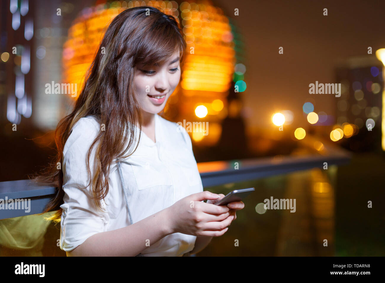 beautiful asian girl using mobile phone at night Stock Photo - Alamy