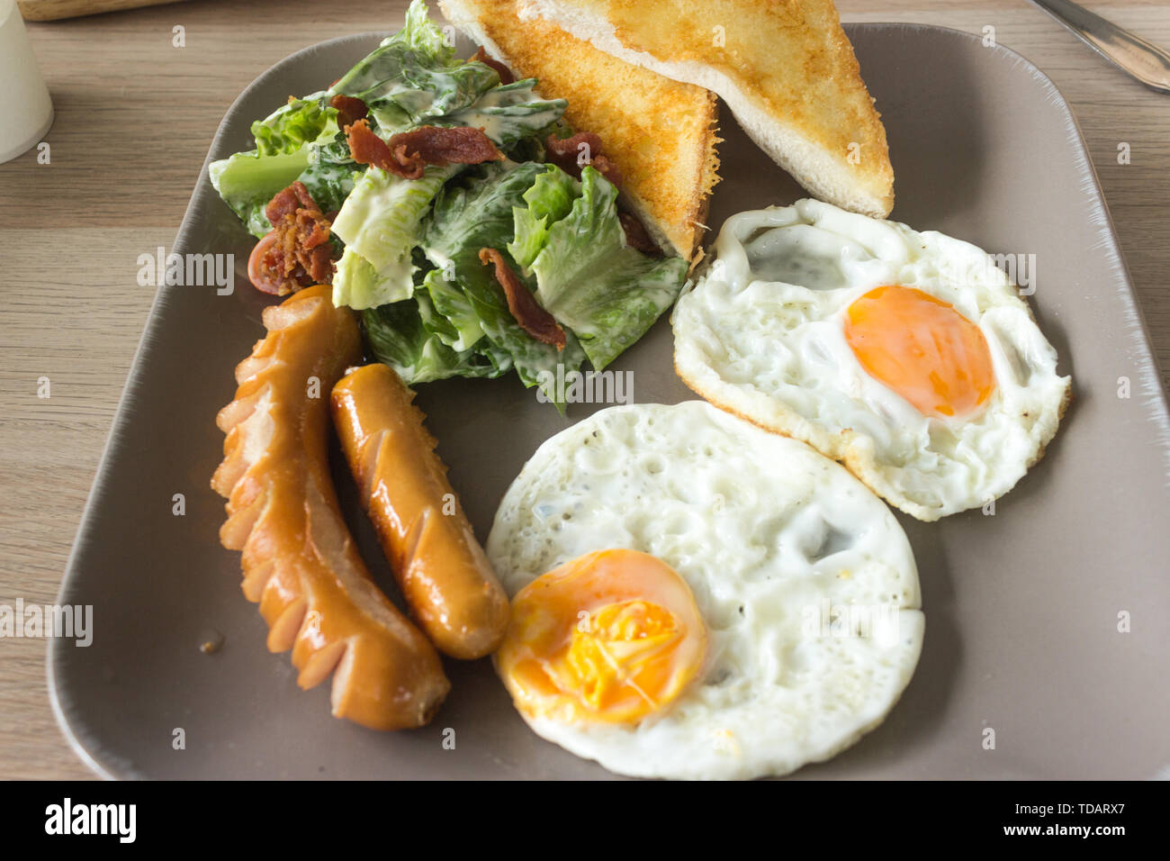 Set of american breakfast with fried eggs and sausage on wood table background. Stock Photo