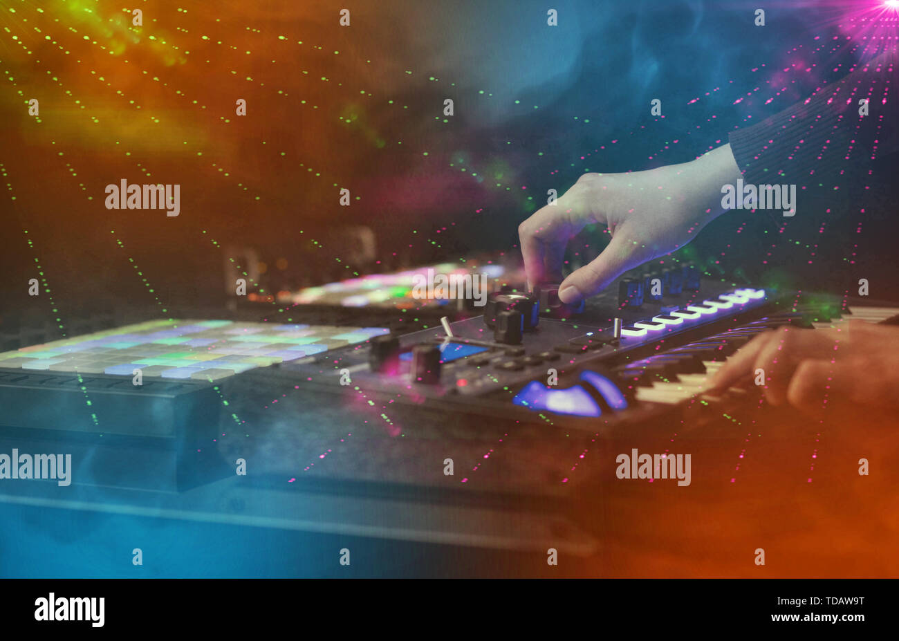 Midi Controller Hand Hand mixing music on midi controller with party club colors around ...