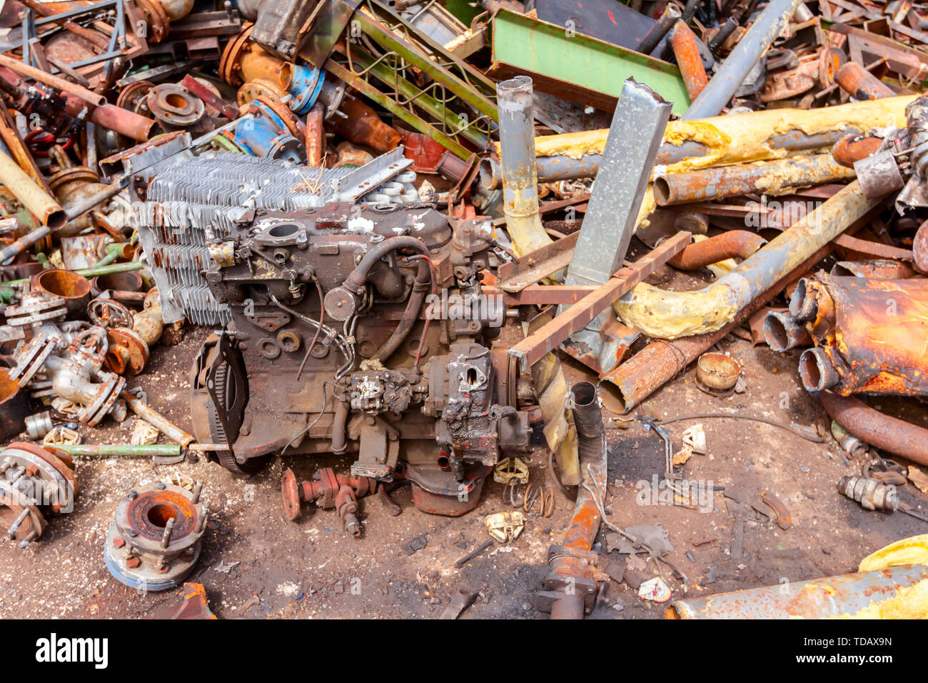 Aged internal combustion engine is placed among rusted parts of