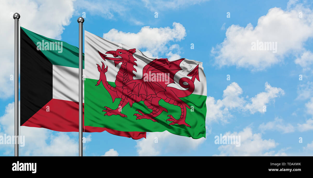Kuwait and Wales flag waving in the wind against white cloudy blue sky ...