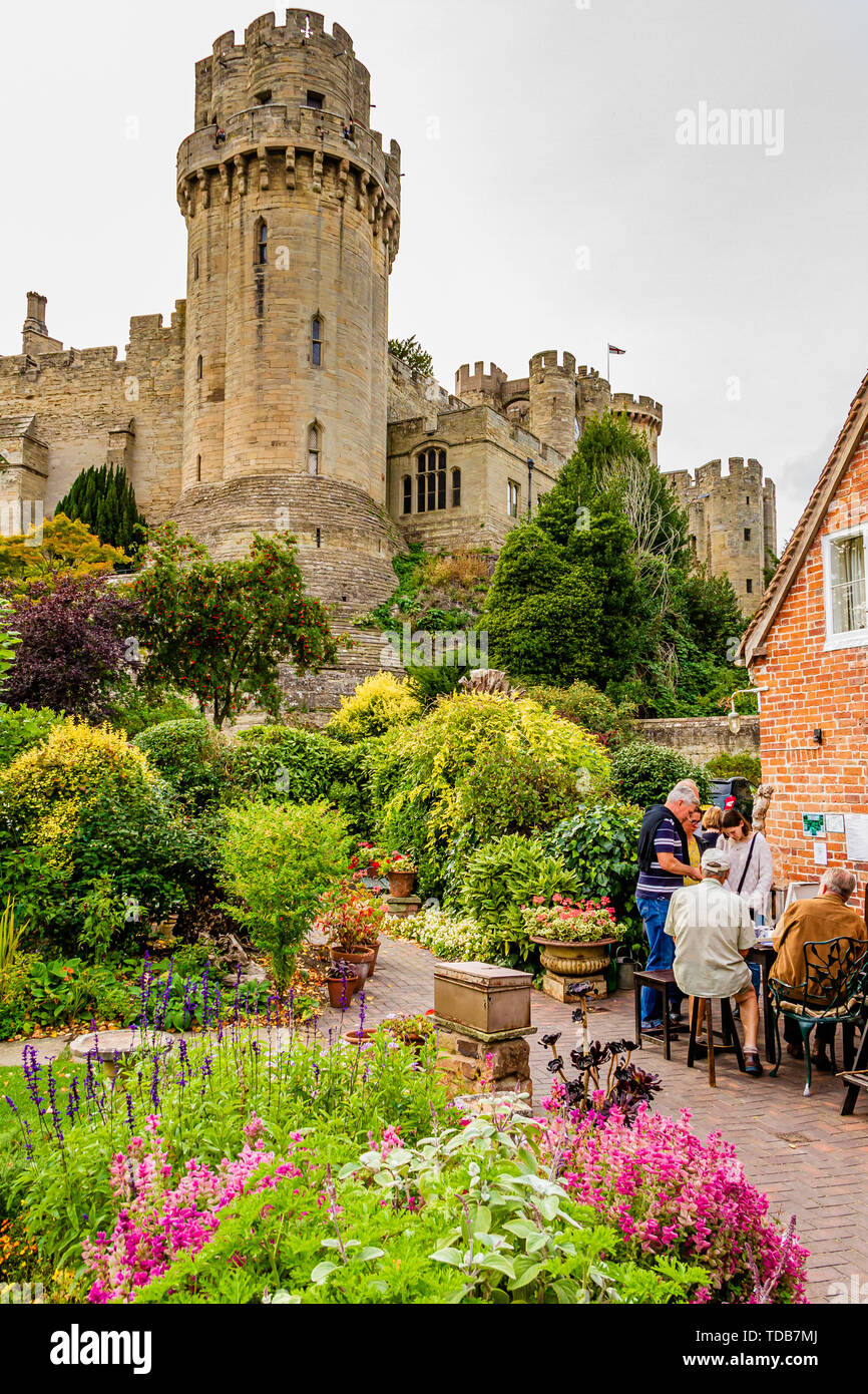 Visitors to The Mill Garden with its view of Caesar's Tower, Warwick Castle. Warwick, UK. Summer 2018. Stock Photo