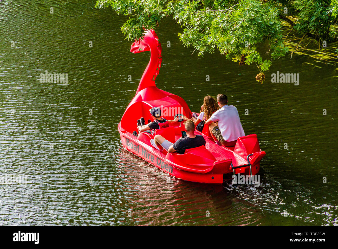 A brightly coloured dragon shaped pedalo on the River Avon, Warwick, Warwickshire. Summer 2018. Stock Photo