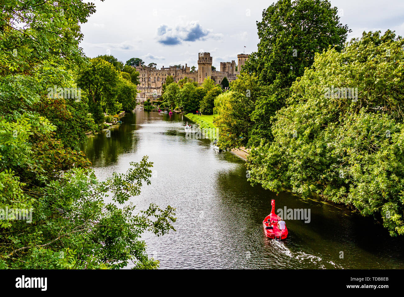 Warwick Castle with tourists in hire boats on the River Avon. Warwick, Warwickshire, UK. Summer 2018. Stock Photo