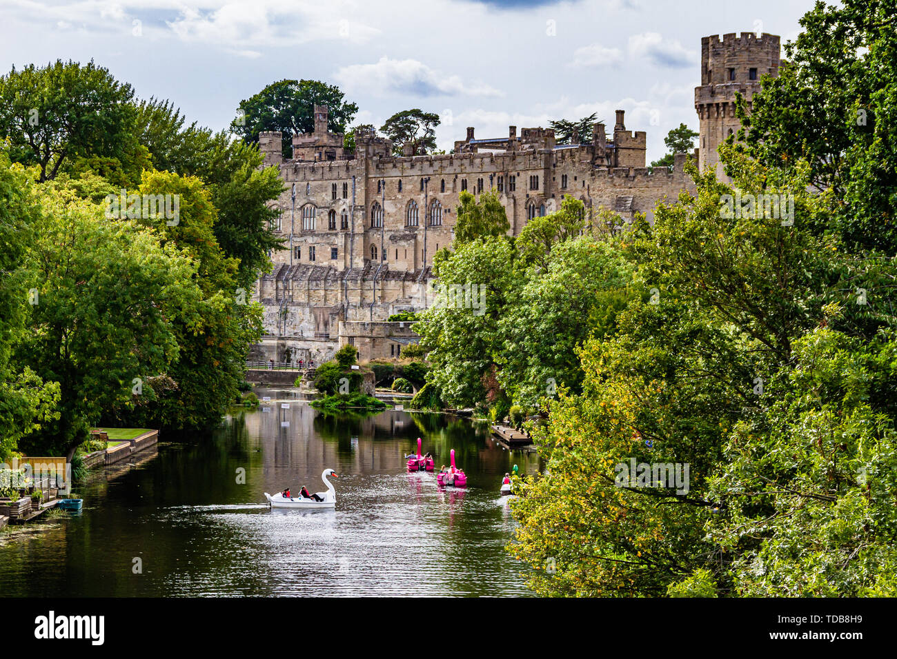 Warwick Castle with tourists in hire boats on the River Avon. Warwick, Warwickshire, UK. Summer 2018. Stock Photo