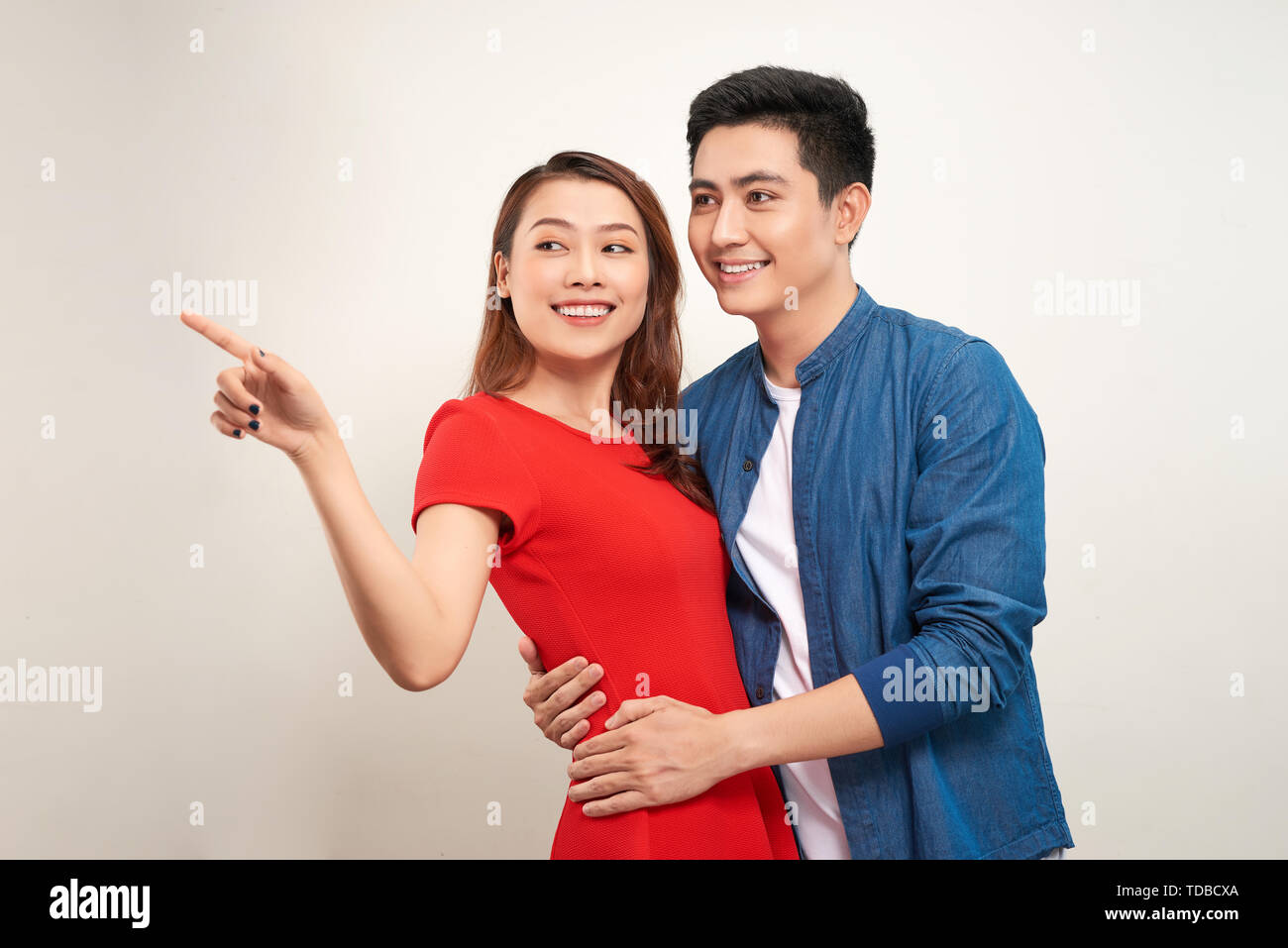 happy couple pointing on white background Stock Photo - Alamy