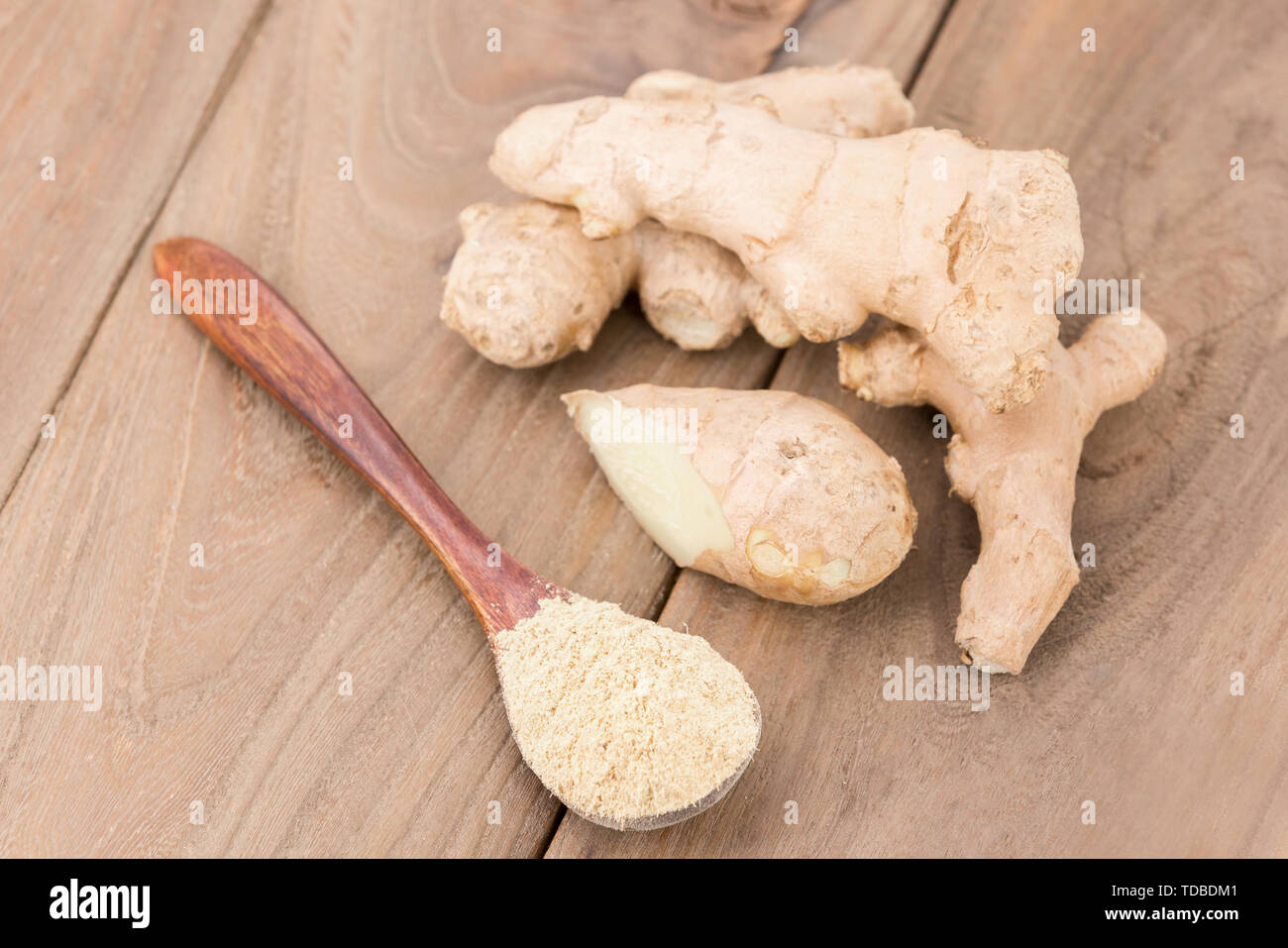 Ginger powder and ginger on wooden table Stock Photo