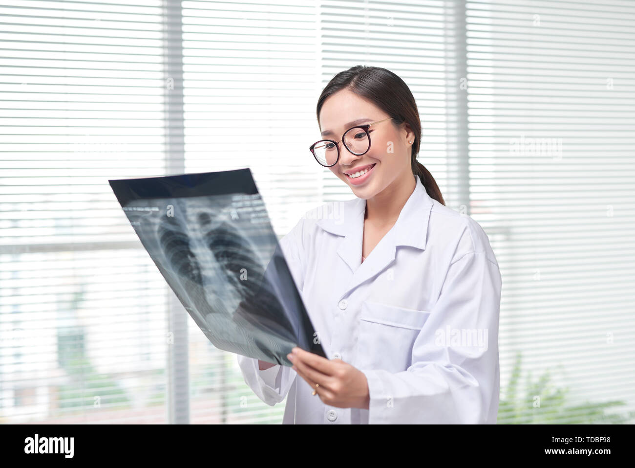 Confident female doctor examining accurately a rib cage x-ray Stock Photo
