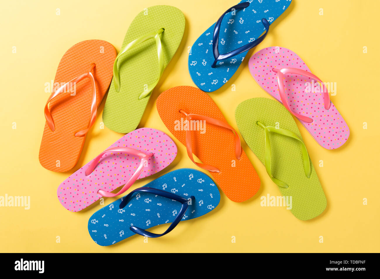 many colored flip flops on yellow background. Copy space top view Stock ...