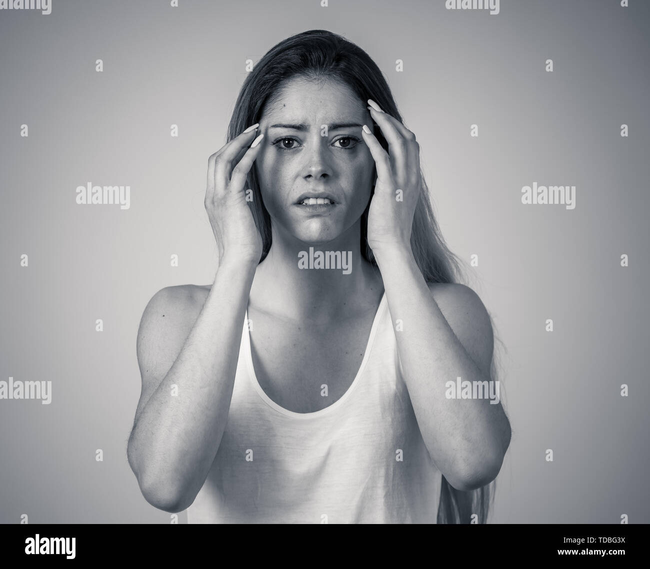 Young woman suffering from depression feeling miserable hopeless and suicidal. Portrait of depressed teen female crying in distress. Facial expression Stock Photo