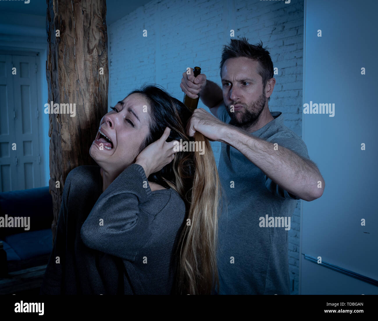 Social issues Domestic violence concept. Alcoholic and abuser partner beating and threatening his terrified wife. Violent man physically abusing scare Stock Photo