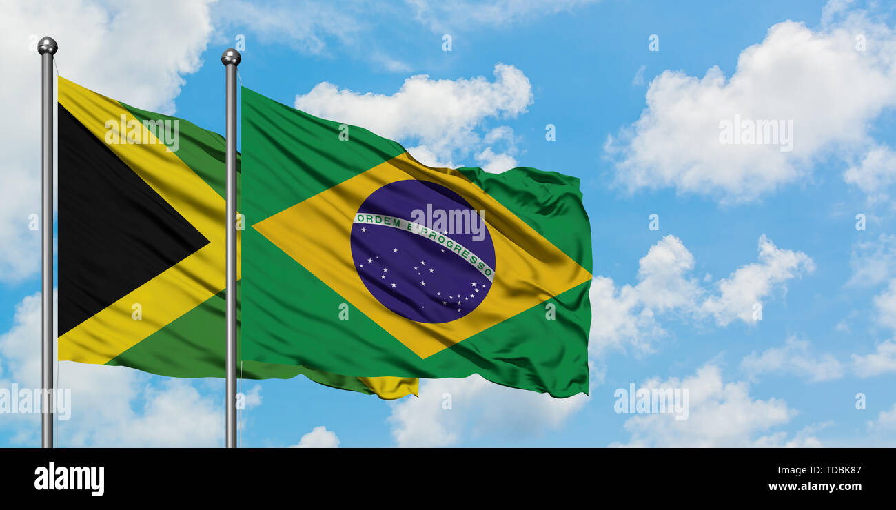 Jamaica and Brazil flag waving in the wind against white cloudy blue ...