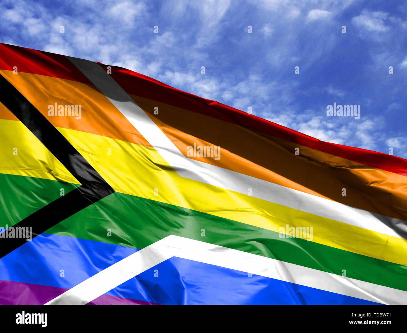 waving flag of Gay pride Flag of South Africa close up against blue sky ...