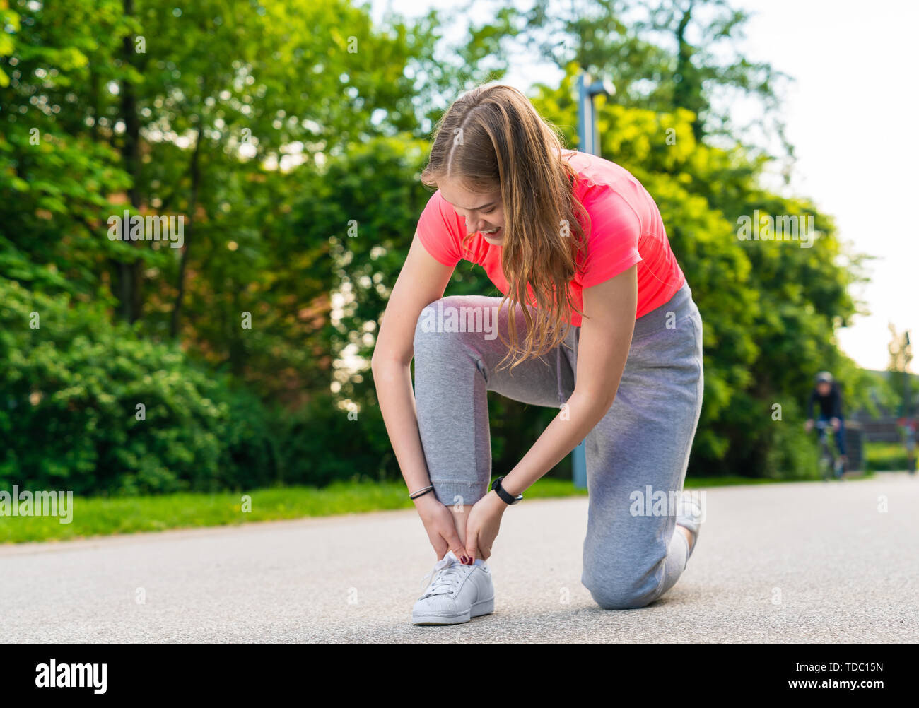 A young female jogger has injured her foot and has a pain Stock Photo