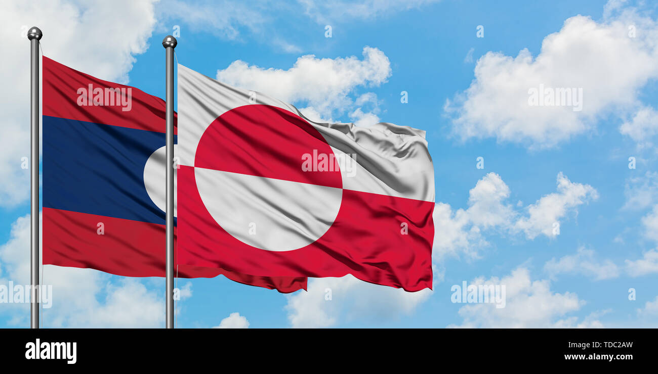 Laos and Greenland flag waving in the wind against white cloudy blue ...