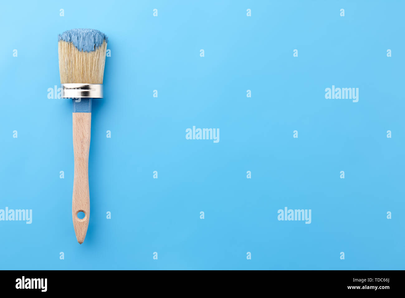 Brush tool in blue paint on blue background, copy space Stock Photo - Alamy