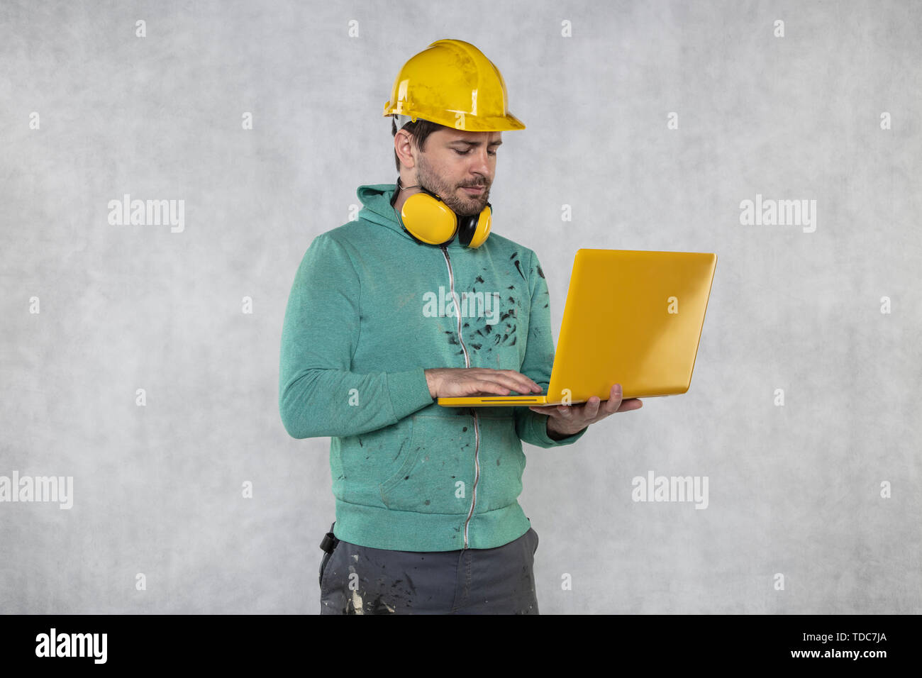 modern building supervisor keeps the computer in his hands, technology at work Stock Photo