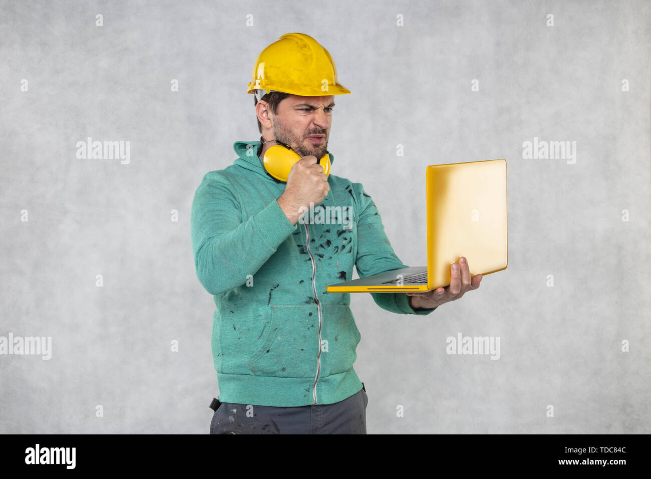 modern building supervisor keeps the computer in his hands, technology at work Stock Photo