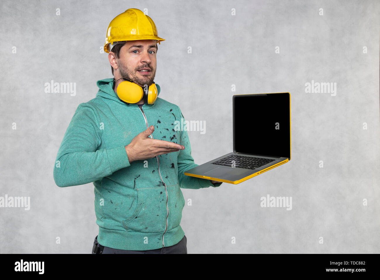 modern building supervisor keeps the computer in his hands, technology at work Stock Photo
