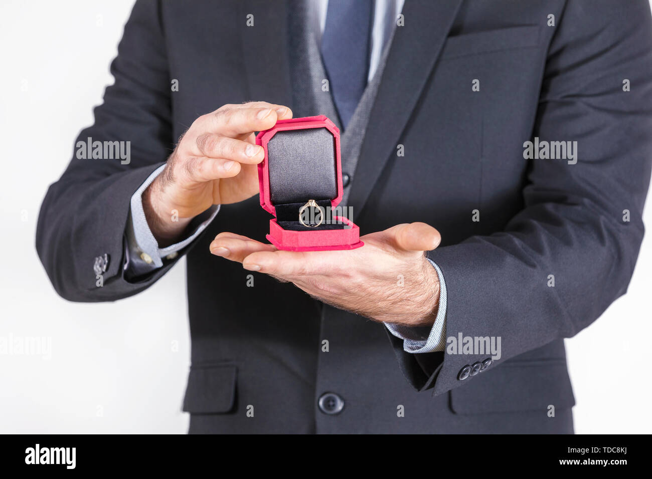 Young Man in suit with tie is holding a box with wedding rings. Time for engagement and step in to adult life. wedding rings as a symbol of happy life Stock Photo